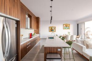 a kitchen with a refrigerator and a living room at Luxury apartment overlooking the Arch in Cabo San Lucas