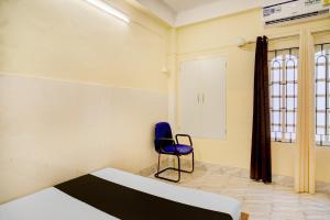 a room with a bed and a blue chair at Collection O GNRC Hospital Dispur Formerly Shree Vinayak Guest House in Guwahati