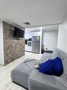sala de estar con sofá gris y TV en Entire home in Lechería, Venezuela, en El Morro de Barcelona