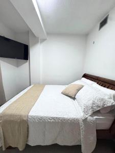 Un dormitorio con una cama y un televisor de pantalla plana. en Entire home in Lechería, Venezuela, en El Morro de Barcelona
