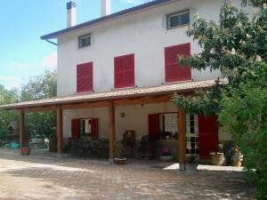 a white house with red shutters on it at B&B Da Mariella in Spigno Saturnia