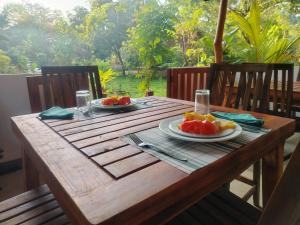 una mesa de madera con dos platos de fruta. en WILAPTTU WILD VILLA, en Pahala Maragahawewa