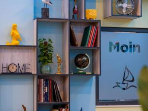 a book shelf with books and other items on it at Aparthotel Adagio Access Kiel City in Kiel +91 photos