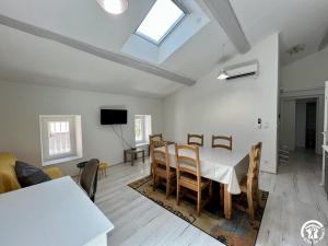 Un comedor con mesa y sillas y una ventana. en Sous les etoiles, en Canet d'Aude