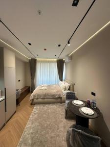 ein Schlafzimmer mit einem Bett und einem Tisch darin in der Unterkunft TASHKENT CITY PREMIUM NRG U tower 8 floor, 106 in Taschkent