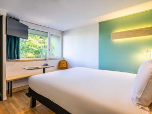a bedroom with a bed and a desk and a window at greet Brussels Airport Zaventem in Zaventem +36 photos