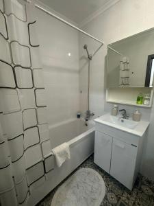 a white bathroom with a tub and a sink at ЖК Smart House, апартаменты возле Триумфальной арки и ботанического сада in Astana