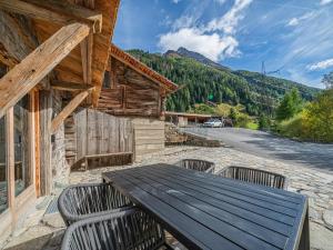 a wooden table and chairs on the patio of a cabin at Raneburg 4 Stallhaus in Matrei in Osttirol