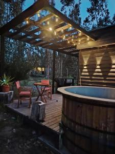 une terrasse avec un bain à remous et une pergola dans l'établissement Cabaña Matanzas tinaja privada vista al bosque, à Boca Pupuya