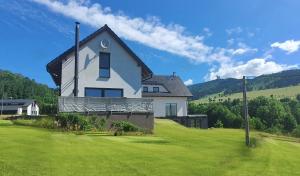 een huis op een heuvel met een groen gazon bij Chalet Dolní Morava in Dolní Morava