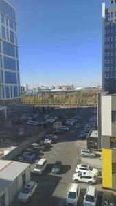 a parking lot with cars parked in a parking lot at ЖК Smart House, апартаменты возле Триумфальной арки и ботанического сада in Astana