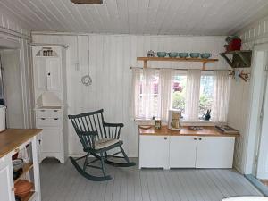 a kitchen with a chair and a desk and a window at Mummon mökki in Mäntylahti