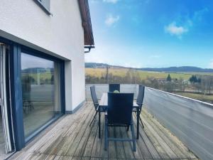 a table and chairs on the deck of a house at Chalet Dolní Morava in Dolní Morava