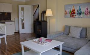 a living room with a couch and a stove at Inselblume 07 - Ferienwohnung mit Hund an der Reiterkoppel in Neue Tiefe Fehmarn