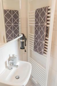a bathroom with a sink and a mirror at Inselblume 66 - Kuschlige Ferienwohnung für 2 in Landkirchen in Landkirchen