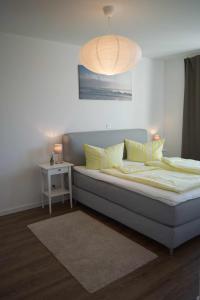 ein großes Bett mit gelben Kissen in einem Zimmer in der Unterkunft Inselblume 46 - Ferienwohnung in Burg mit Balkon und viel Licht in Burg auf Fehmarn