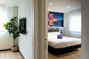 a bedroom with a bed and a potted plant at ibis Styles Santander in Santander +55 photos
