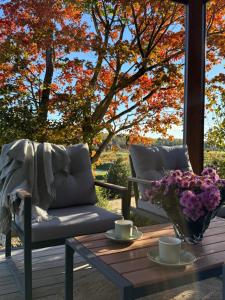 a porch with a table and a couch and flowers at Poilsio namelis in Kretingalė