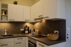 a kitchen with white cabinets and a counter top at Inselblume 49 - Ferienwohnung im Erdgeschoss der Strandburg in Burgtiefe auf Fehmarn 