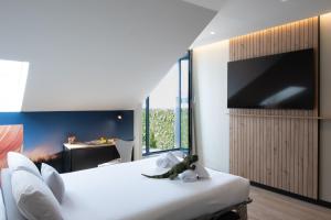 a bedroom with a large white bed with a large flat screen tv at ibis Styles Santander in Santander