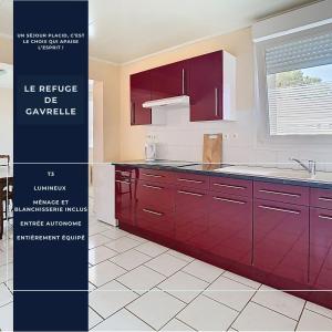 a kitchen with red cabinets and a white tile floor at Le campagnard in Gavrelle