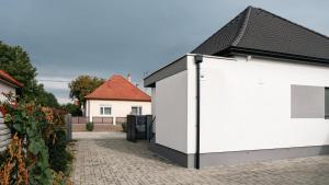 a white house with a black roof at Star house Sereď in Seredʼ