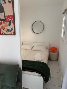 a small bedroom with a bed with a mirror at Casa Maxima - Cosy et Calme à 2 pas de la Mer in Sainte-Maxime