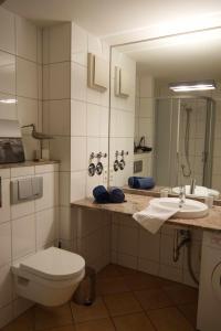 a bathroom with a toilet and a sink and a mirror at Inselblume 50 - Ferienwohnung von privat in der Strandburg in Burgtiefe auf Fehmarn 
