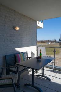 a table and chairs on a patio with a bottle of wine at Inselblume 50 - Ferienwohnung von privat in der Strandburg in Burgtiefe auf Fehmarn 