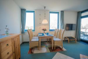 un salon avec une table et des chaises de salle à manger dans l'établissement Inselblume 14 - Blaue Ferienwohnung mit Balkon am Südstrand, à Burgtiefe auf Fehmarn  4 autres photos
