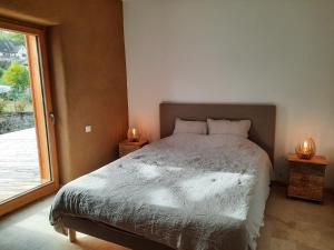 a bedroom with a bed and a window with two candles at Au blé dormant in Wihr-au-Val +4 photos