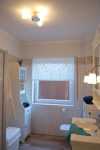 a bathroom with a sink and a toilet and a window at Inselblume 05 - Große Ferienwohnung in Landkirchen mit Hund in Landkirchen +29 photos
