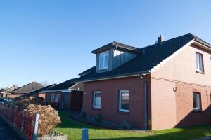 a red brick house with a black roof at Inselblume 05 - Große Ferienwohnung in Landkirchen mit Hund in Landkirchen