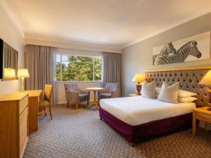 una habitación de hotel con una cama y un escritorio en Mercure Hotel Windhoek, en Windhoek