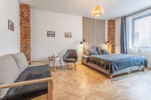 a bedroom with a bed and a chair and a couch at Penzion Malý in Krnov