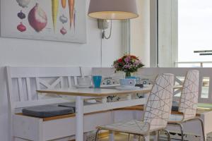 - une table à manger avec 2 chaises et une table dans l'établissement Inselblume 37 - Ferienwohnung mit Meerblick im Stranddistelweg 58, à Burgtiefe auf Fehmarn 