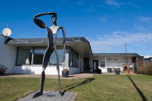 Burgtiefe auf Fehmarn にあるInselblume 82 - Bungalow am Südstrand mit Meerblickの建物前の女性の金属彫刻