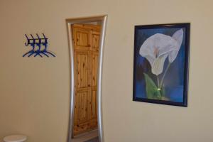 a painting of a flower on a wall next to a mirror at Inselblume 39 - Komfortable Ferienwohnung mit Waschmaschine in Burg in Burg auf Fehmarn