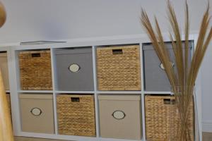 une étagère avec des paniers et un vase dans l'établissement Inselblume 34 - Ferienwohnung mit Loggia, à Burg