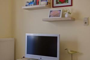 a computer monitor sitting on a desk with a bird next to it at Inselblume 38 - Zentrale Ferienwohnung in Burg mit Garten in Burg auf Fehmarn