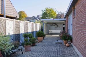 a brick walkway with potted plants and a fence at Inselblume 38 - Zentrale Ferienwohnung in Burg mit Garten in Burg auf Fehmarn