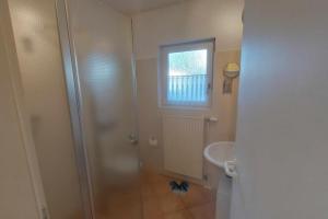 a bathroom with a shower and a sink at Inselblume 38 - Zentrale Ferienwohnung in Burg mit Garten in Burg auf Fehmarn