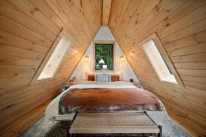 ブーンにあるAscent A-Frame at Calm Ridge Treehousesのベッドルーム1室(大型ベッド1台、窓2つ付)