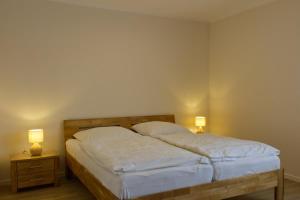 a bedroom with a bed with two lamps on both sides at Inselblume 40 - Ferienhaus mit Garten in Dänschendorf in Westfehmarn