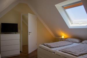 two beds in a bedroom with a skylight at Inselblume 09 - Ferienwohnung an der Reiterkoppel auf Fehmarn in Neue Tiefe Fehmarn