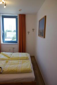 two beds in a room with a window at Inselblume 01 - Ferienwohnung mit Meerblick und Balkon am Südstrand in Burgtiefe auf Fehmarn 