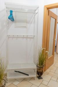 un placard blanc avec une étagère et un couteau dans l'établissement Inselblume 62 - Strandnahe Ferienwohnung am Südstrand, à Burgtiefe auf Fehmarn 