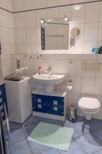 une salle de bain avec un lavabo, des toilettes et un miroir dans l'établissement Inselblume 62 - Strandnahe Ferienwohnung am Südstrand, à Burgtiefe auf Fehmarn 