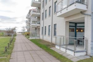 un trottoir vide devant un bâtiment dans l'établissement Inselblume 62 - Strandnahe Ferienwohnung am Südstrand, à Burgtiefe auf Fehmarn 