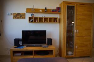 Il comprend un salon avec une télévision et une table en bois avec un appareil de télévision. dans l'établissement Inselblume 45 - Ferienwohnung mit Blick auf den Yachthafen, à Burgtiefe auf Fehmarn 